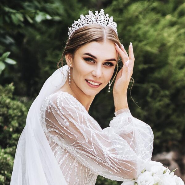 Bride wears a tall crystal crown that is encrusted with crystals that sparkle beautifully.
